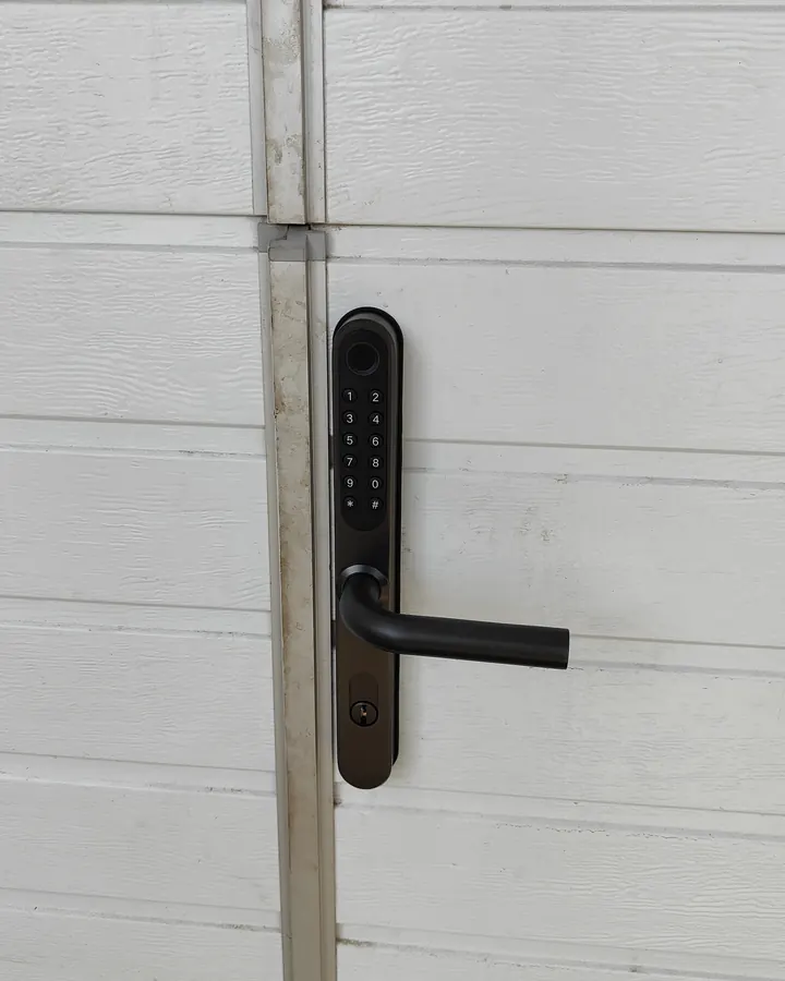 Узкий умный замок TTLock Slim на калитке секционных ворот